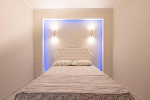 - une chambre avec un lit blanc et une porte bleue dans l'établissement Διαμέρισμα με αυλή στη Μέλισσα, à Xánthi