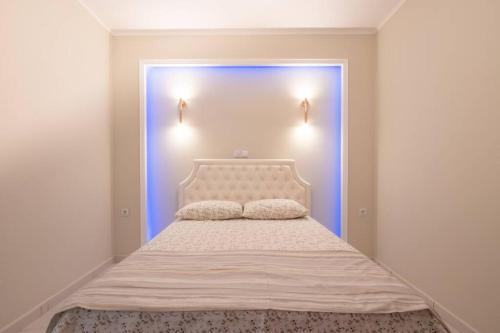 a bedroom with a white bed with a blue door at Διαμέρισμα με αυλή στη Μέλισσα in Xanthi