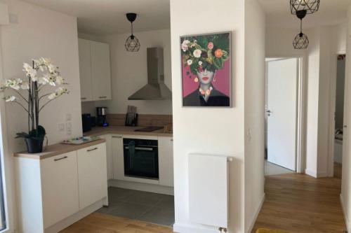 a kitchen with a painting of a woman with flowers at Very nice 40m quiet with parking space in Suresnes