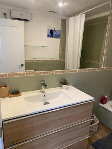 a bathroom with a sink and a large mirror at Apartamento alpino Plaza de Andalucía a pie de pistas in Sierra Nevada