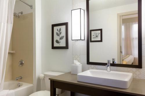 a bathroom with a sink and a toilet and a mirror at Country Inn & Suites by Radisson, Minneapolis West, MN in Plymouth