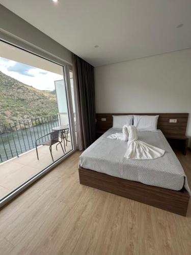 1 dormitorio con cama y ventana grande en Vilas Quinta da Pedra Caldeira, en Armamar