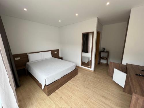 1 dormitorio con cama blanca y espejo en Vilas Quinta da Pedra Caldeira, en Armamar