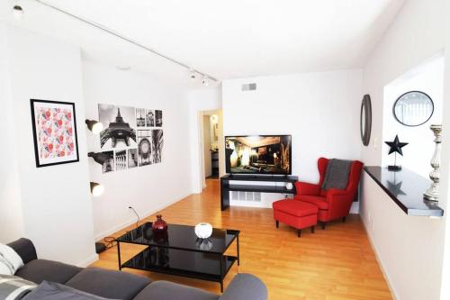 a living room with a couch and red chairs at Hollywood Business Apartments in Los Angeles