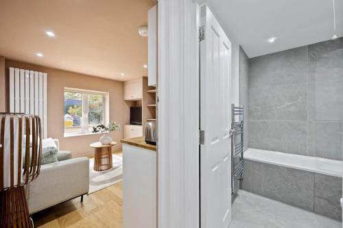un soggiorno con vasca da bagno e una cucina di Camden Garden Apartments a Londra