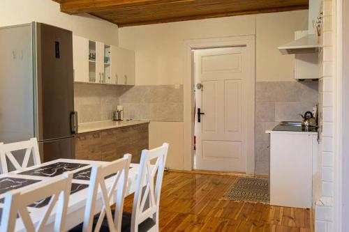 a kitchen with a table and chairs and a white door at Domek nad rzeką in Zatory