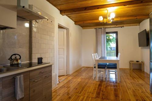 a kitchen with a table and chairs in a room at Domek nad rzeką in Zatory