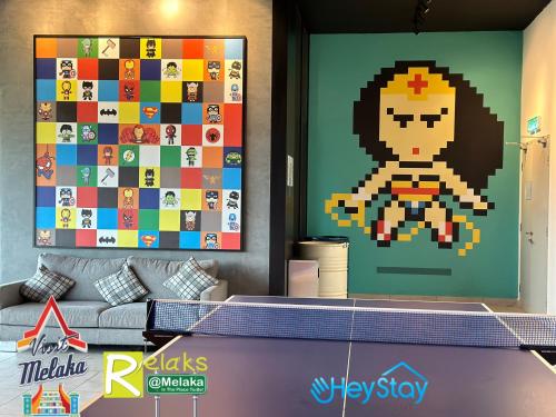 a living room with a pixel game on the wall at Amber Cove Impression City By Heystay Management in Melaka