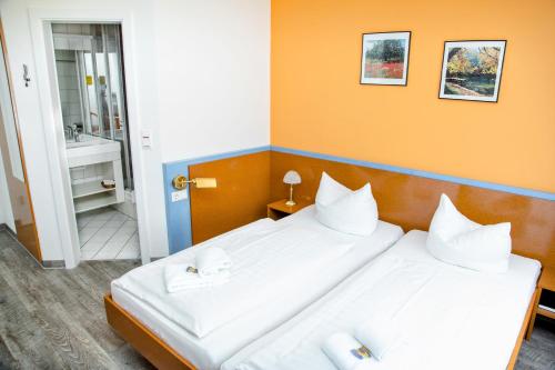 two beds in a room with orange walls at Waldhotel Friedrichroda in Friedrichroda