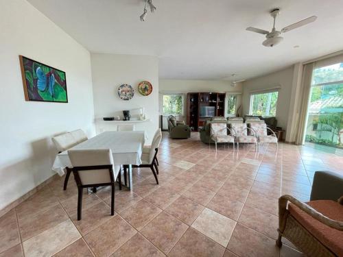 a dining room and living room with a table and chairs at Casa de campo, com quadra de Beach Tennis, Volei e Fut Volei próxima a SP!! in Santana de Parnaíba