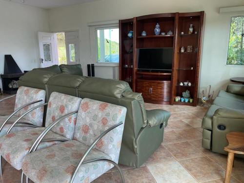 een woonkamer met een bank en stoelen en een televisie bij Magnífica casa de campo, próxima a São Paulo!! in Santana de Parnaíba