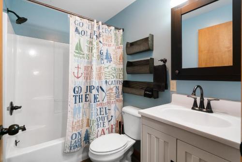 a bathroom with a toilet and a sink and a mirror at Fife Lake Lodge 2BR with Kitchen & Lake Views in Fife Lake