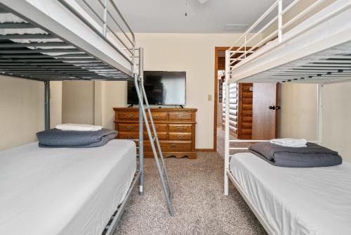 Ce dortoir comprend 2 lits superposés et une télévision. dans l'établissement Fife Lake Lodge 2BR with Kitchen & Lake Views, à Fife Lake