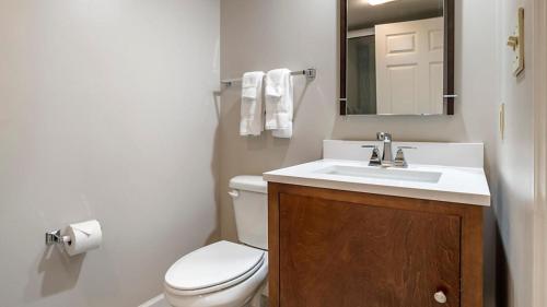 a bathroom with a toilet and a sink and a mirror at Bluegreen Vacations Suites at Hershey in Hershey