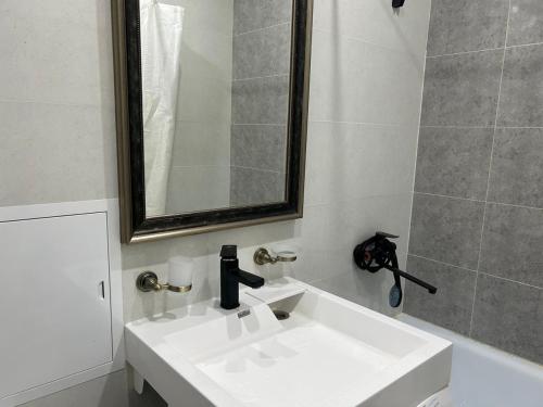 a bathroom with a white sink and a mirror at Квартира в Актау 362 in Aktau