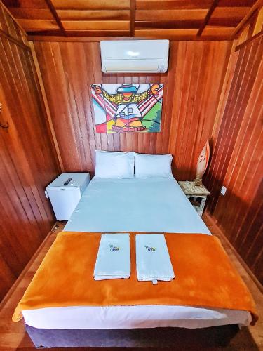 a bedroom with a bed in a wooden room at POUSADA POR DO SOL in Olímpia