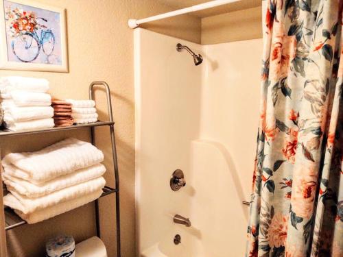 y baño con ducha, aseo y toallas. en Spacious Lakeside Country Getaway! en Hot Springs