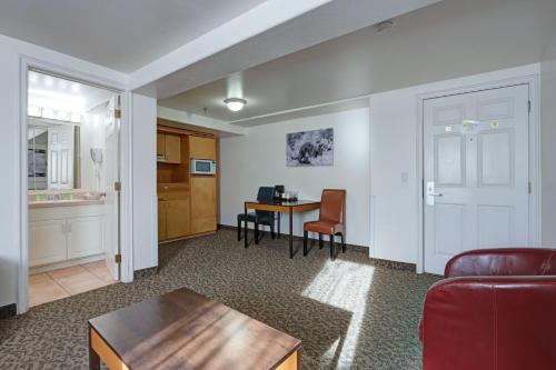 a living room with a table and a kitchen at Puffin Inn in Anchorage