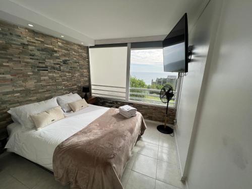 a bedroom with a bed and a large window at Reñaca Frente al Mar in Viña del Mar