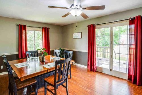 une salle à manger avec une table et des rideaux rouges dans l'établissement Enjoyable Home by Airport & Dwtn, à Rochester