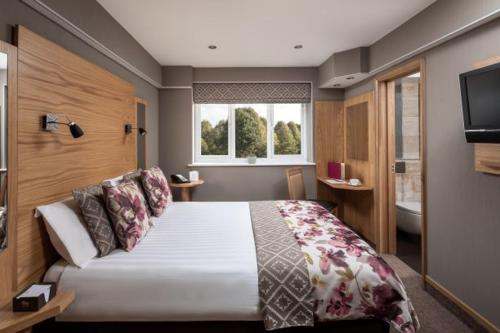 a bedroom with a large bed and a television at Fairlawns, Hotel And Spa in Walsall