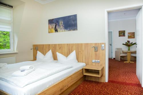 a bedroom with a large bed with white sheets at Waldhotel Friedrichroda in Friedrichroda