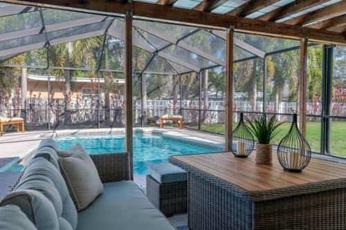 a patio with a couch and a table and a pool at Beautiful 5 bedroom Clearwater home close to beach in Clearwater