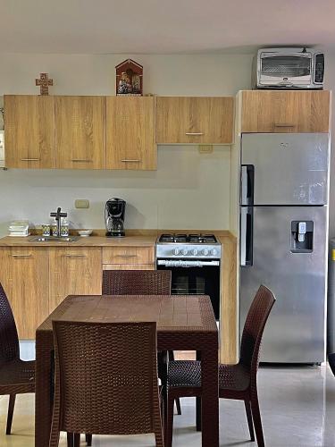 a kitchen with a table and a stainless steel refrigerator at Hospitalidad y confort in Caracas