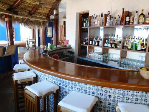a bar with a wooden counter and stools at Casa Natalia Boutique Hotel Adults Only in San José del Cabo