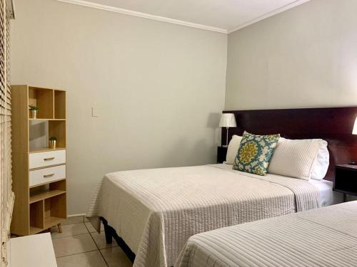 um quarto de hotel com duas camas e uma cómoda em Jardín de la Nonna #1 em San Pedro Sula