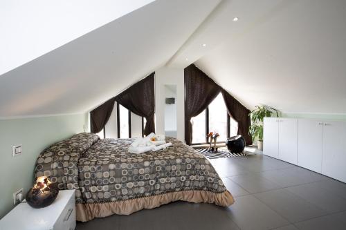 um quarto com uma cama grande num sótão em Villa Belohorizonte em Macerata
