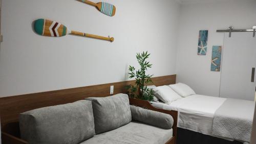 a living room with a couch and a bed at Amarílis Riviera-Estúdio A-209 in Bertioga