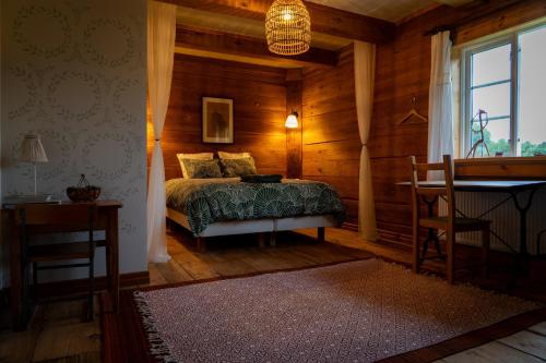 a bedroom with a bed in a wooden room at La Maison Rouge de Slätten Bed and Breakfast in Vilshult