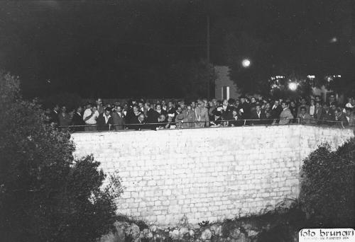 a crowd of people standing behind a brick wall at Matarrese 1950 in Castellana Grotte
