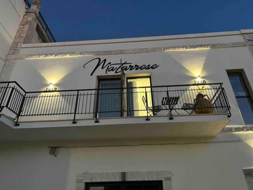 a white building with a balcony with a sign on it at Matarrese 1950 in Castellana Grotte