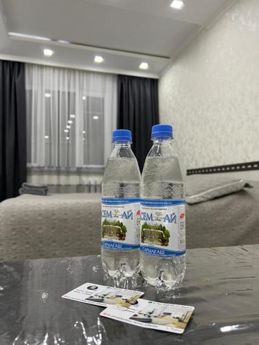 dos botellas de agua sentadas sobre una mesa en Байзак- батыра 187, en Taraz