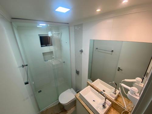 y baño con ducha acristalada y lavamanos. en Apartamento AV. Brasil Frente Sh. Atlântico, en Balneário Camboriú