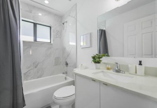 uma casa de banho branca com um WC e um lavatório em Stunning 3-Bedroom Duplex with Free Parking em Miami