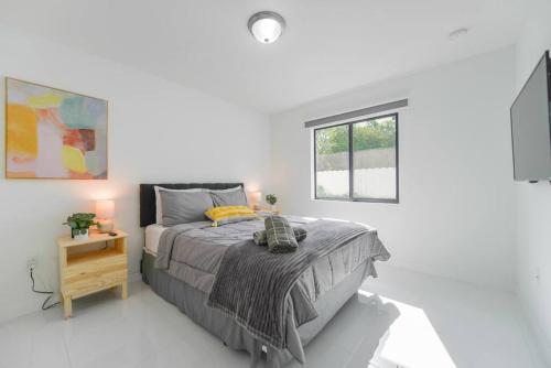 um quarto branco com uma cama e uma janela em Stunning 3-Bedroom Duplex with Free Parking em Miami