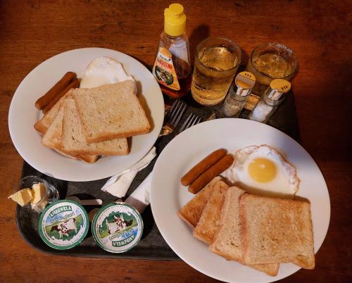 a tray with two plates of toast and an egg and sausage at CHEN VILLA - Near Airport in Negombo