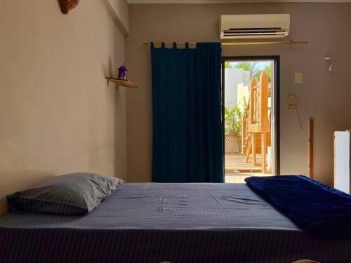 a bedroom with a bed and a sliding glass door at BohemiaHouse - Duplex By the sea in Dahab