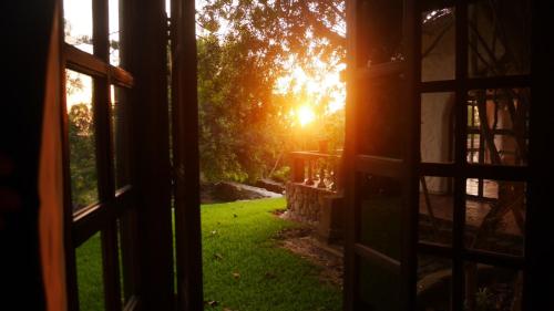 an open door to a yard with the sun in the background at Darenas Hacienda in Aucallama
