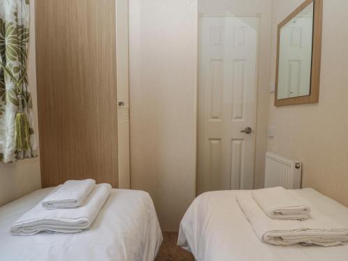 a room with two beds with white sheets and a mirror at Dove in Leominster