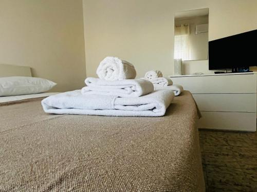 una pila de toallas en una cama en una habitación de hotel en SHUBY HOME, en San Pietro Vernotico