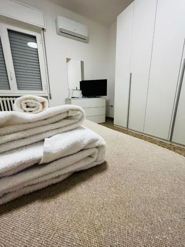 a bedroom with white furniture and towels on the floor at SHUBY HOME in San Pietro Vernotico