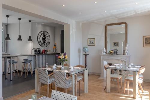 ein Esszimmer und eine Küche mit einem Tisch und einem Spiegel in der Unterkunft La Salamandre in Beauvais