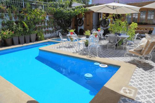 een zwembad met een tafel en stoelen en een parasol bij Hotel Boutique Vendimia Premium in Santa Cruz