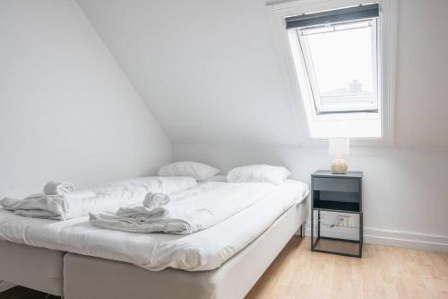 a white bedroom with a bed and a window at Centrum Condo with Terrace in Bergen