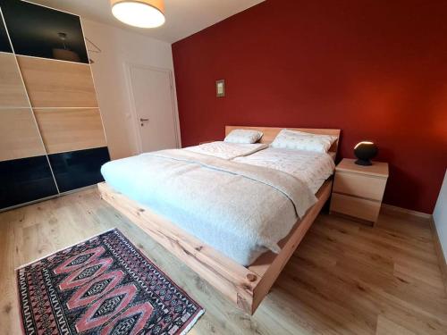 a bedroom with a large bed and a red wall at Michael's City Retreat in Graz