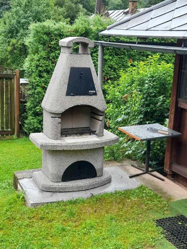 a stone oven in a yard with a table at Chalupa pod sjezdovkou in Chvaleč